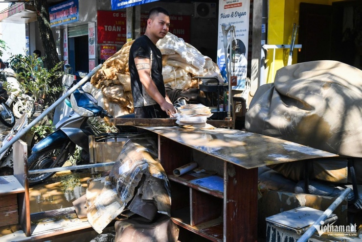 Kéo hết đồ đạc trong văn phòng ra ngoài, anh Quang chia sẻ: "Văn phòng của tôi cao chỉ 1 tầng nên những ngày qua nước dâng ngập mái. Đồ đạc hỏng hết rồi, giờ vứt cả chứ nhặt nhạnh được gì đâu”.&nbsp;