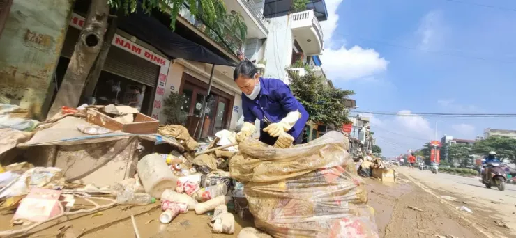 Người dân đang cố tìm kiếm những món đồ còn có giá trị trong đống đổ nát sau lũ.
