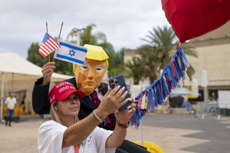 Người phụ nữ chụp ảnh cùng người đeo mặt nạ ông Trump ở quảng trường.