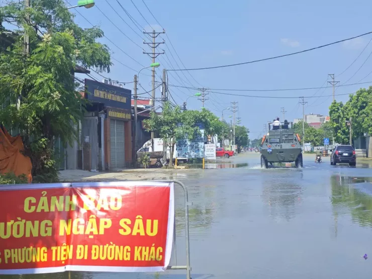 Bộ Công an huy động xe đặc chủng lội nước đưa người dân di chuyển qua chỗ ngập sâu trên đoạn đường Quốc lộ 3 cũ qua địa phận xã Trung Giã. Tuyến đường này bị ngập một đoạn kéo dài cả km từ phố Nỉ hướng về phía nội thành Hà Nội. Ảnh: Trọng Phú