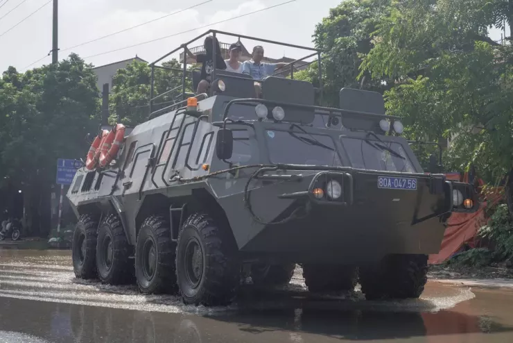 Người dân được đưa qua chỗ ngập trên Quốc lộ 3 cũ. Ảnh: Trọng Phú