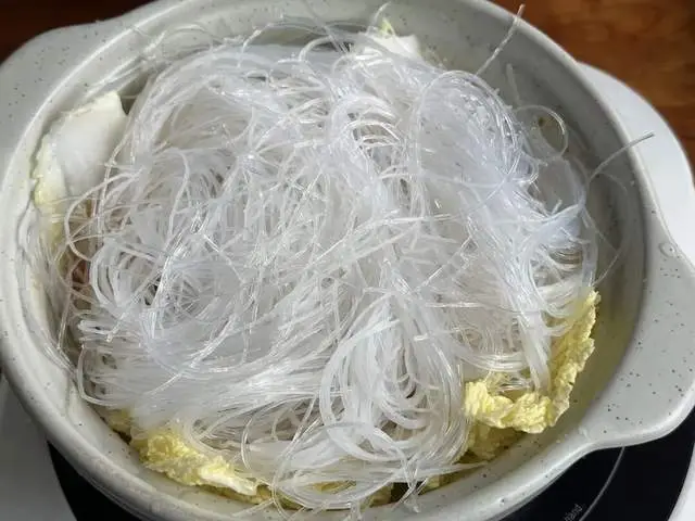 Ngâm miến trong nước ấm cho mềm rồi để ráo, trải đều lên lớp cải thảo. Không nên ngâm quá lâu, giữ lại chút độ dai để khi nấu không bị bở, ăn sẽ ngon hơn.