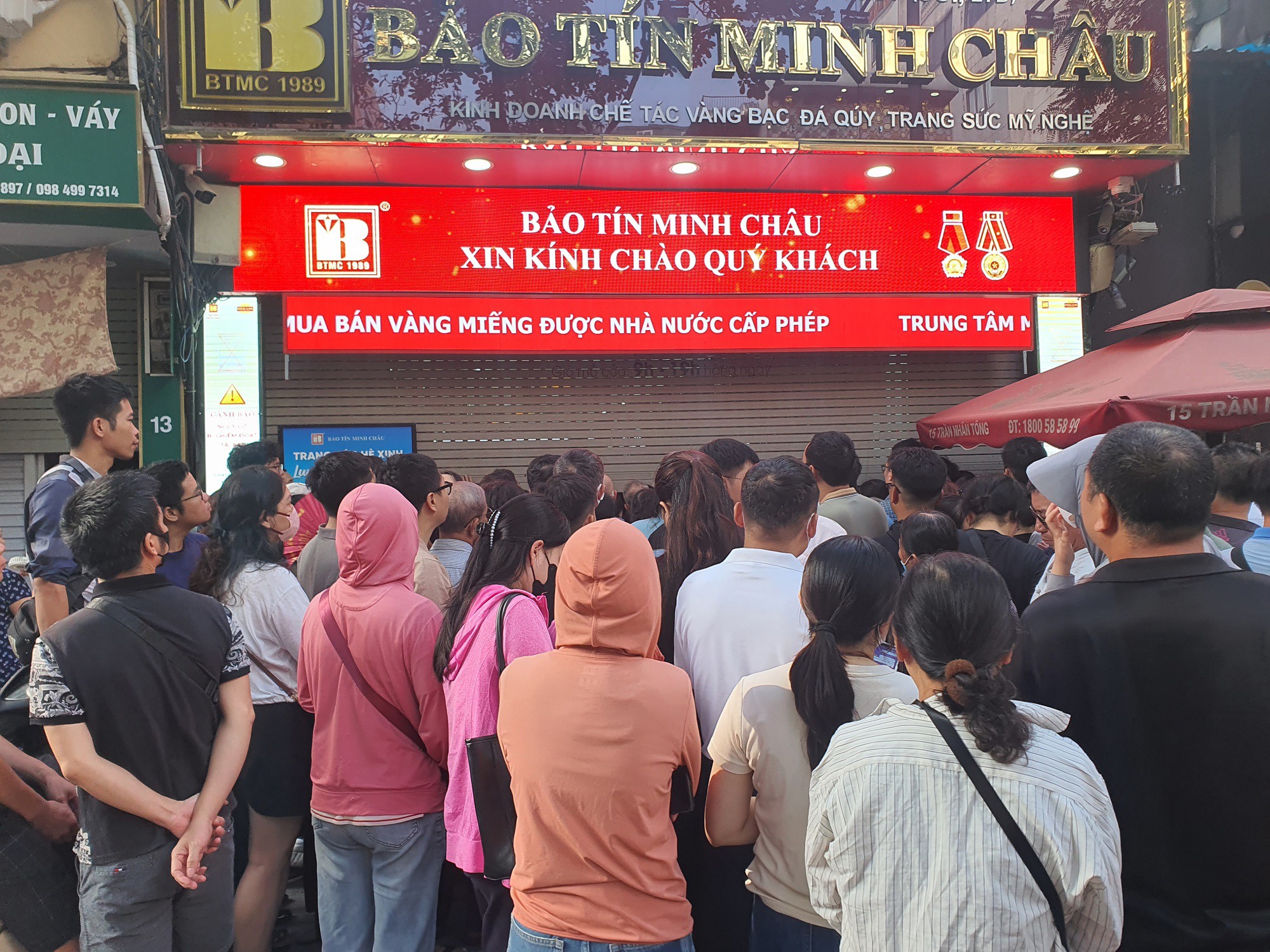 Cửa cuốn của cửa hàng đã hạ, nhân viên thông báo ngừng bán và yêu cầu đám đông giải tán, không tập trung trước cửa hàng nhưng vẫn không khả thi. Hàng trăm người vẫn cố nán lại, chen chúc nhau chờ cửa hàng mở cửa.