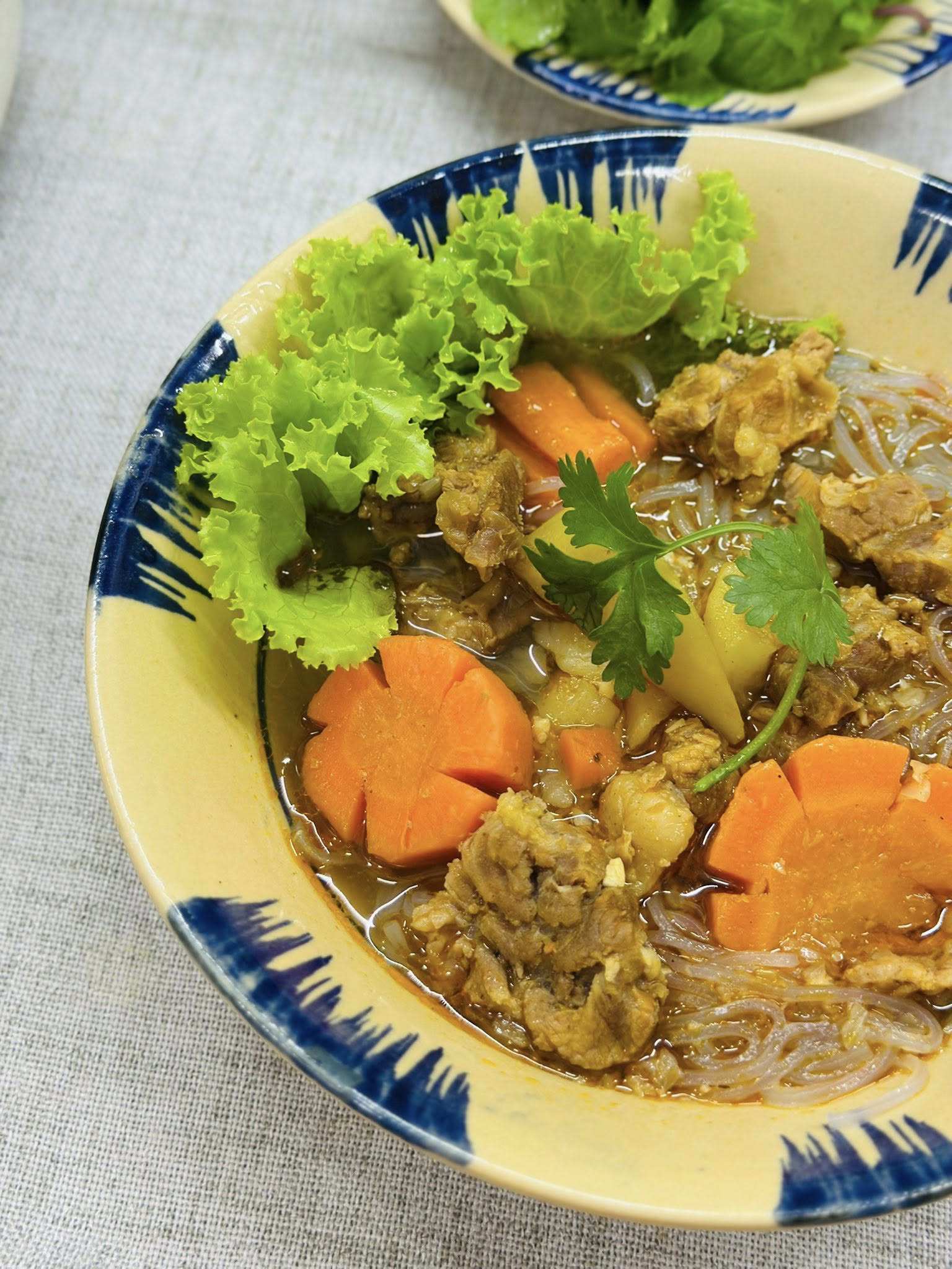 Nêm nếm lại cho vừa miệng. Trụng hủ tiếu, chan nước bò kho, thêm hành ngò, ớt, rau thơm.