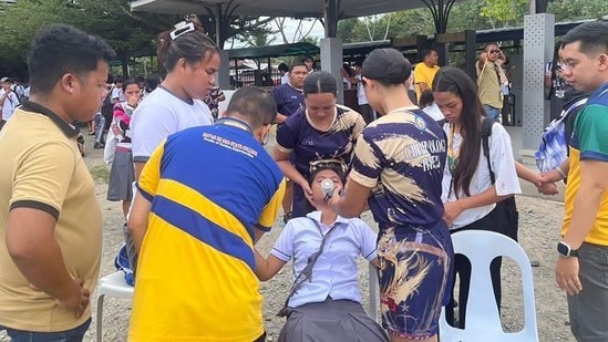 Một học sinh được hỗ trợ sau khi choáng váng vì động đất. Ảnh: AFP