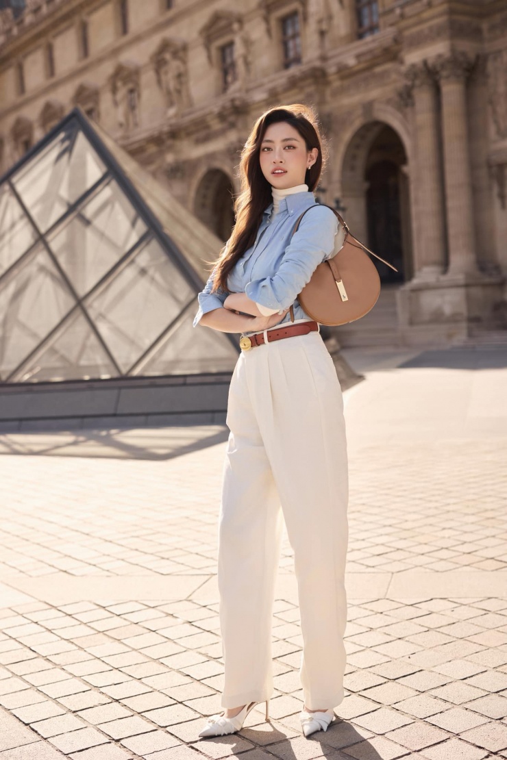 Giữa set đồ tông xanh trắng, điểm nhấn đáng chú ý là chiếc túi nâu hàng hiệu và dây lưng nâu.