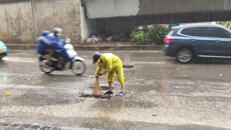 Nhân viên đơn vị này được huy động túc trực trong mưa, làm nhiệm vụ thoát nước trên nhiều tuyến phố Hà Nội sáng nay.