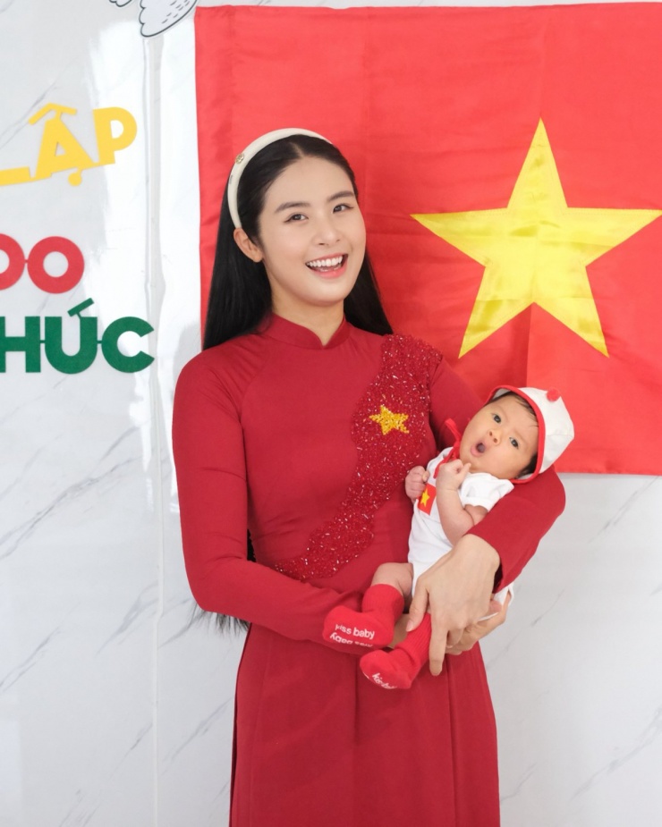 Hoa hậu Ngọc Hân diện áo dài đỏ, bế con trai chụp hình mừng kỷ niệm 71 năm Ngày Giải phóng Thủ đô (10/10/1954 - 10/10/2025). Trong vòng tay mẹ, nhóc tì một tháng tuổi được khen ngộ nghĩnh.