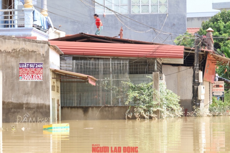 Nước ngập bao vây tứ phía, nhiều người dân phải sinh hoạt trên tầng hai và trên mái nhà. Ảnh: Văn Duẩn