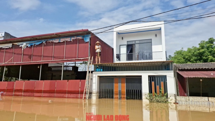 Người dân Tiên Lục thất thần đứng trên mái nhà nhìn xuống dòng nước lũ