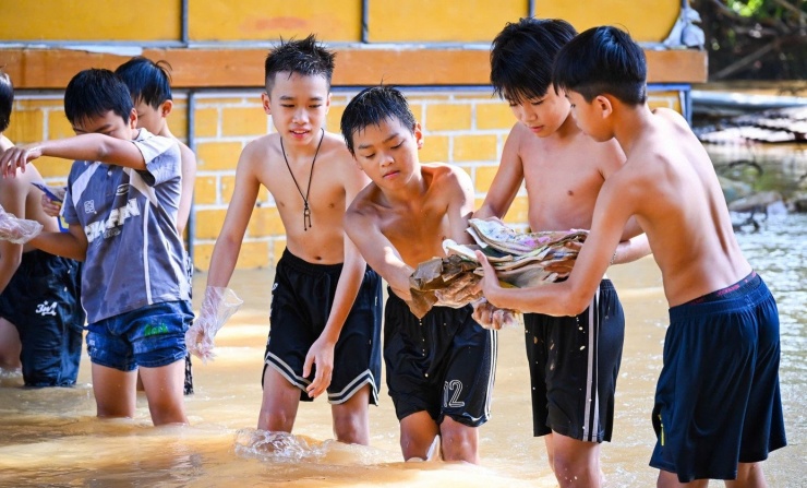 Trân quý sách vở trong dòng nước lũ. Ảnh: ND
