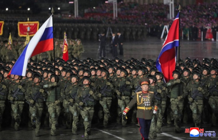 Khối các quân nhân từng tham chiến ở tỉnh Kursk của Nga, mang theo quốc kỳ Triều Tiên và Nga diễu qua lễ đài.