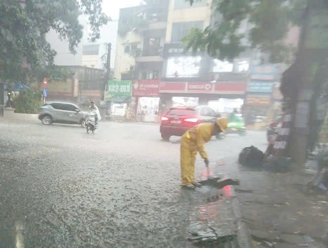Nhân viên Công ty Thoát nước đã khẩn trương khơi thông dòng chảy tại các hố ga trên đường Nguyễn Huy Tưởng.