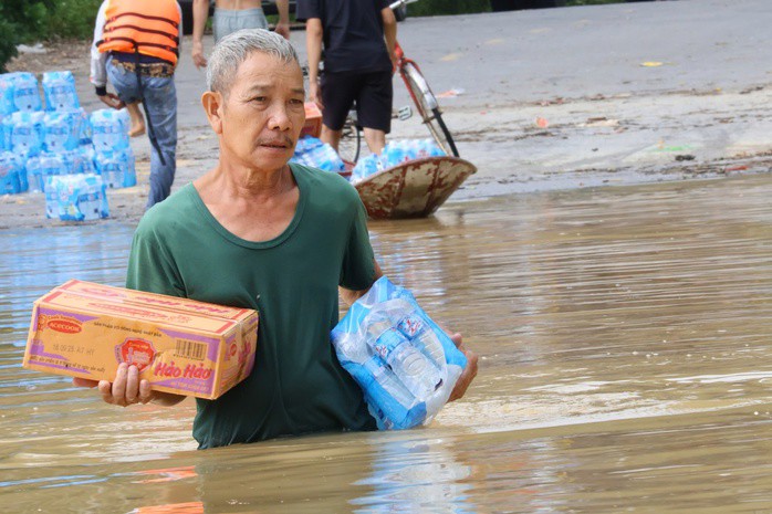 Ông Nguyên lội nước ra điểm nhận hàng cứu trợ