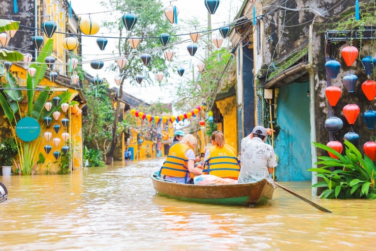 Khách du lịch trải nghiệm dịch vụ tham quan phố cổ mùa lũ.