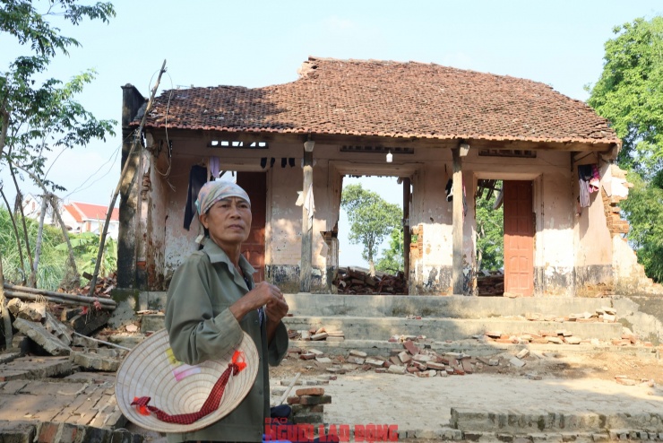 Bà Trương Thị Hoạt ngẩn ngơ bên căn nhà của mình đã bị lũ cuốn hết tài sản. Ảnh: Văn Duẩn