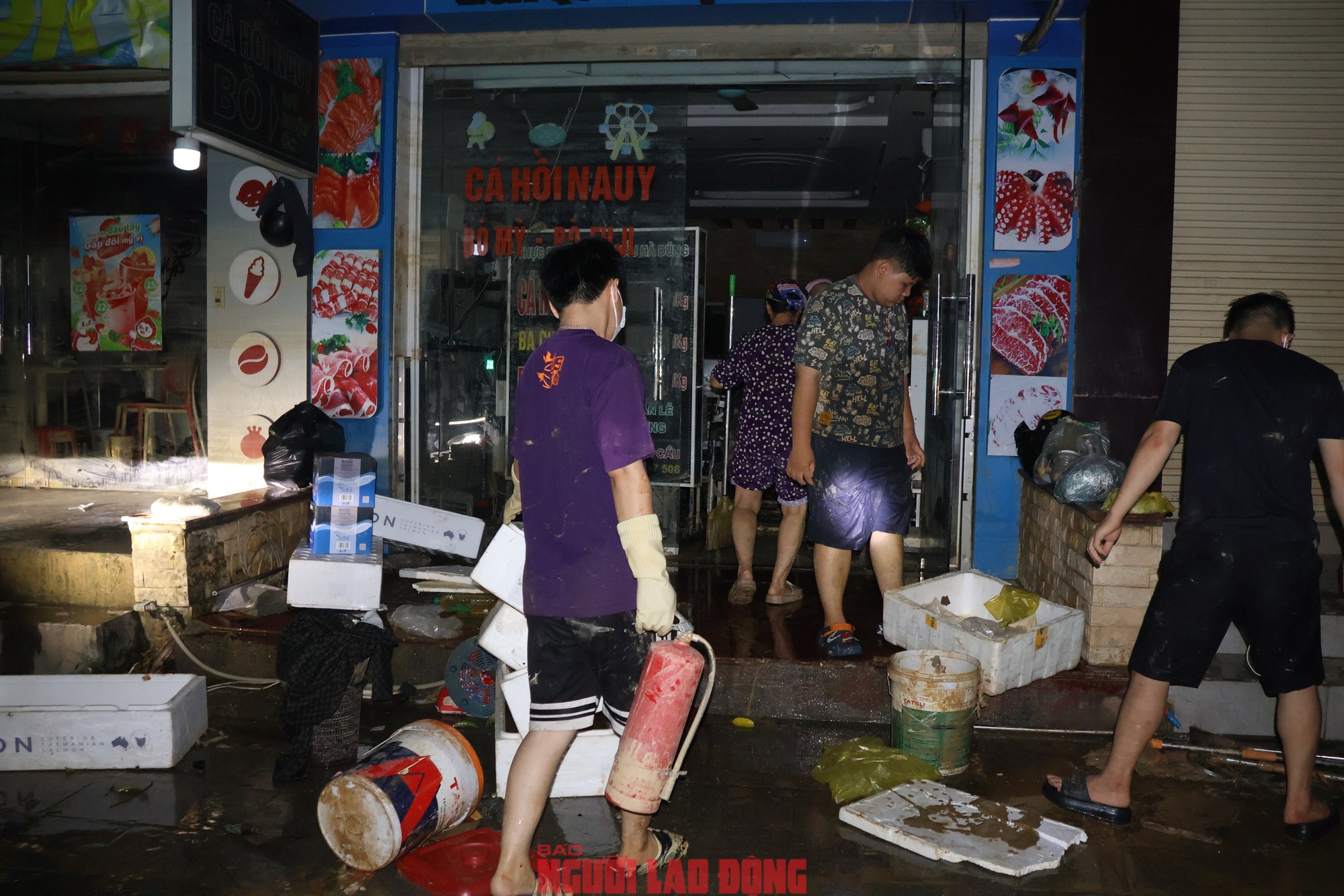 Người dân xuyên đêm dọn dẹp cửa hàng để sớm trở lại hoạt động sản xuất, kinh doanh