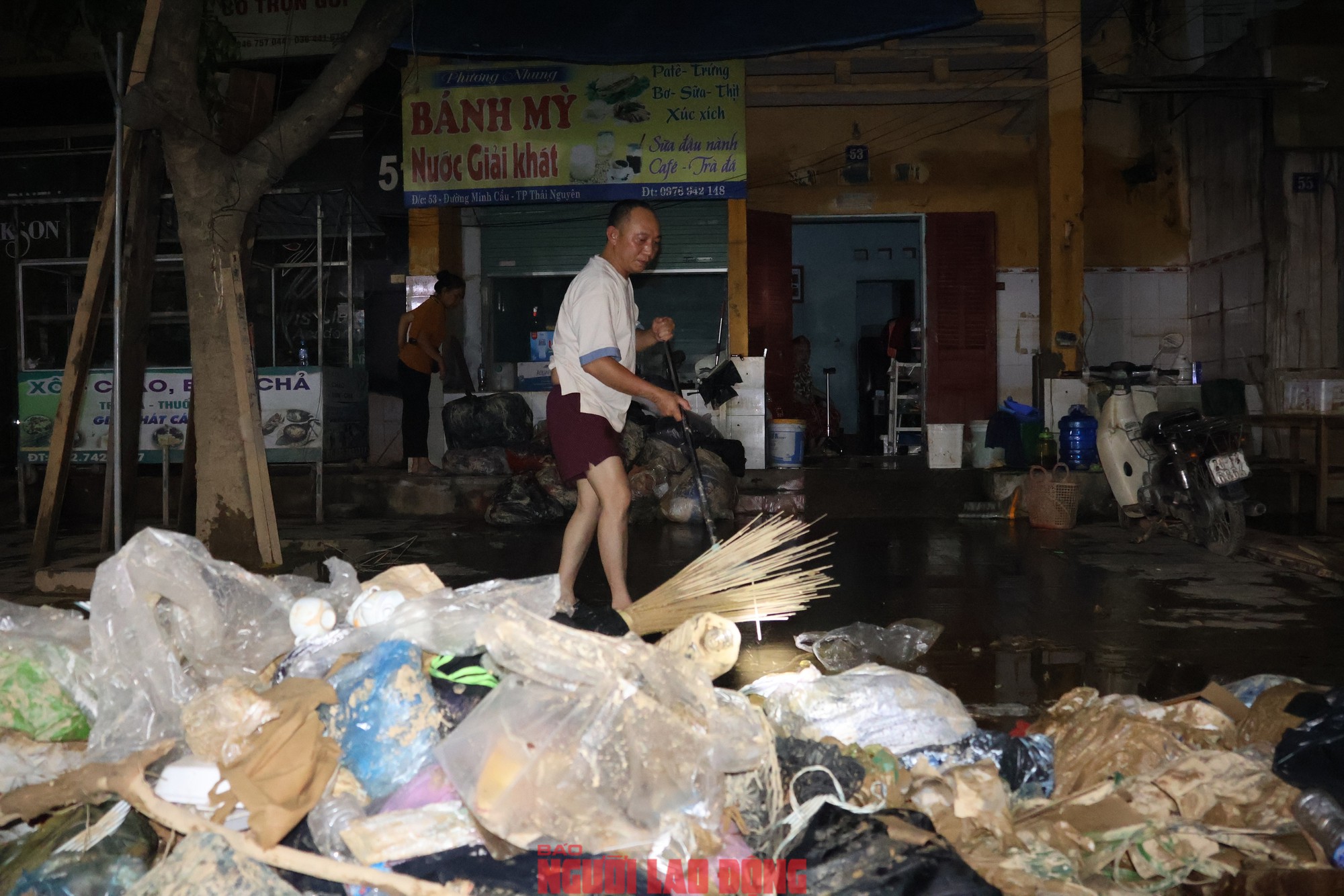 Người dân xuyên đêm dọn dẹp cửa hàng để sớm trở lại hoạt động sản xuất, kinh doanh