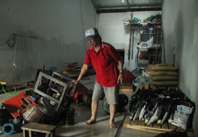 Ông Chuyên đứng trong kho hàng chứa hơn 20 tấn lương thực, nay chỉ còn vài bao gạo, máy móc phải tháo tung để vệ sinh, tại phường Phan Đình Phùng, TP Thái Nguyên chiều 10/10. Ảnh: Phan Dương