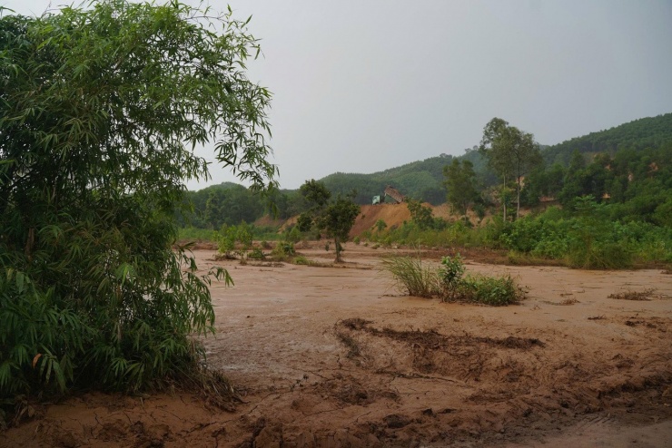 Bùn chứa trong hồ tràn ra đồng ruộng của người dân