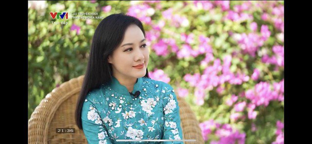 BTV lúc khác thì chọn áo dài điểm xuyết hoa trắng mix tông áo màu xanh dịu dàng.