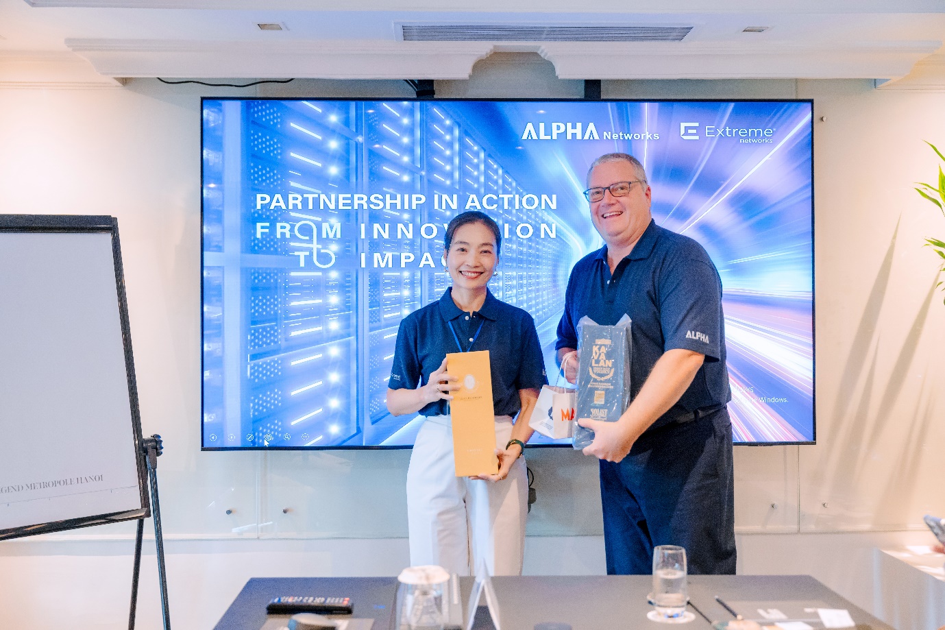 Tổng giám đốc điều hành Alpha Networks In và Phó Chủ tịch Chuỗi cung ứng Extreme Networks trao quà lưu niệm tại sự kiện