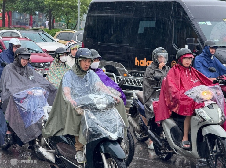 Nhiều người ngao ngán trong cơn mưa lớn. Ảnh: Anh Phú