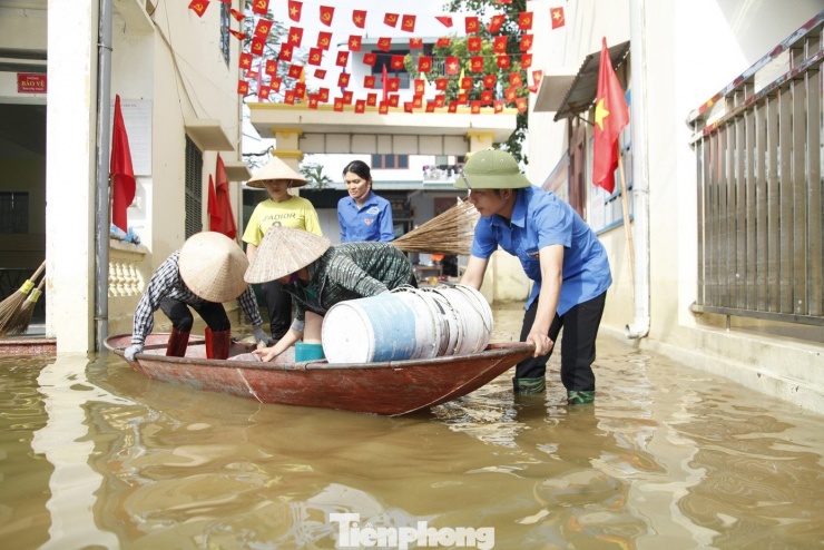 Di chuyển bằng thuyền để dọn dẹp vệ sinh các lớp học. Ảnh: Nguyễn Thắng