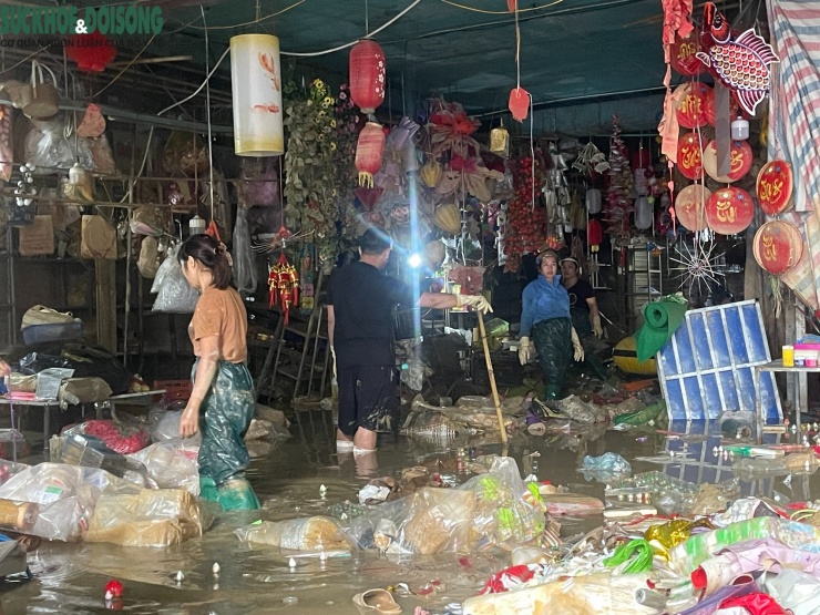 Nhiều tiểu thương đang "vật lộn" giữa bùn đất và hàng hóa hư hỏng.