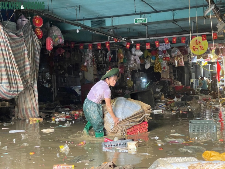 Chị Đoàn Thị Loan cố vớt vát lại những gì còn sót lại sau ngập lụt.