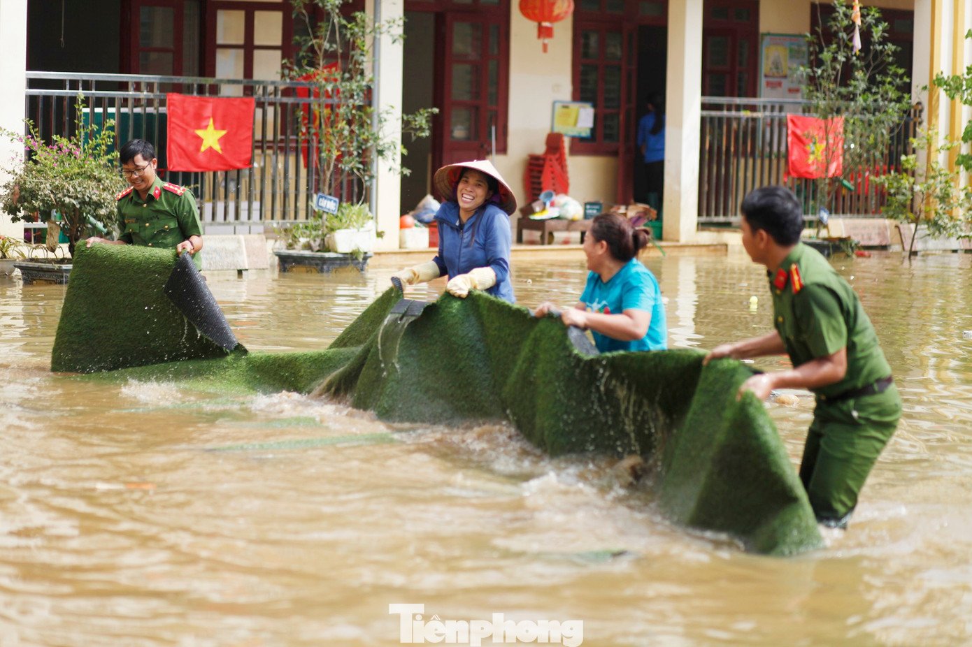 Các cô giáo và công an bì bõm lội nước thu dọn trường học. Ảnh: Nguyễn Thắng