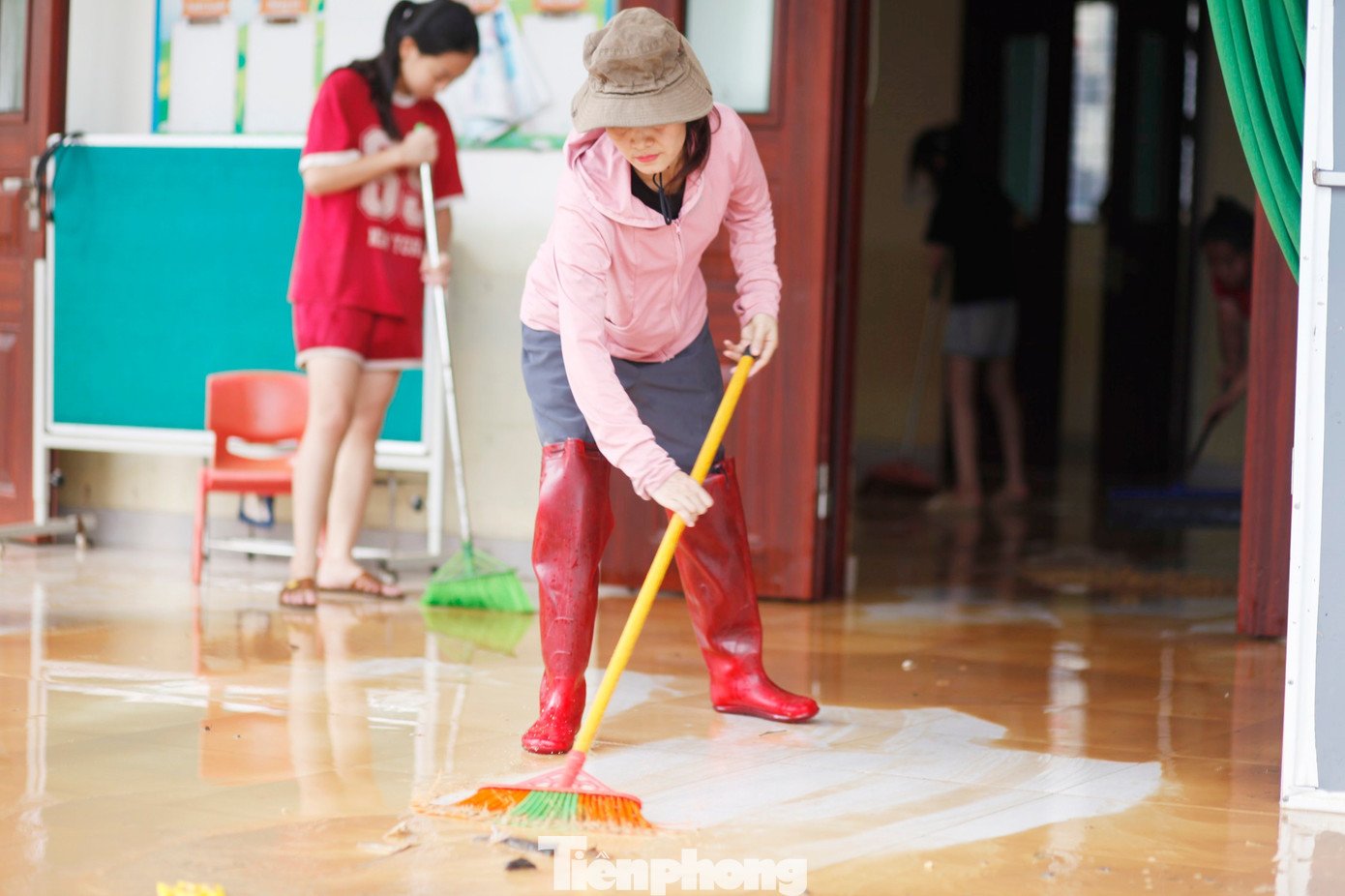 Các cô giáo thu dọn bùn đất ở lớp học. Ảnh: Nguyễn Thắng