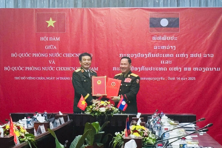 Đại tướng Phan Văn Giang và Thượng tướng Khamliang Outhakaysone ký kết Bản ghi nhớ giữa Bộ Quốc phòng Việt Nam và Bộ Quốc phòng Lào về tăng cường hợp tác trong lĩnh vực đào tạo, tập huấn, bồi dưỡng nguồn nhân lực. Ảnh: BQP