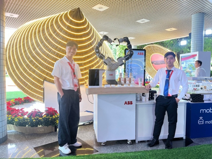 Trần Duy Khanh (trái) chuẩn bị gian triển lãm sản phẩm công nghệ tiêu biểu.