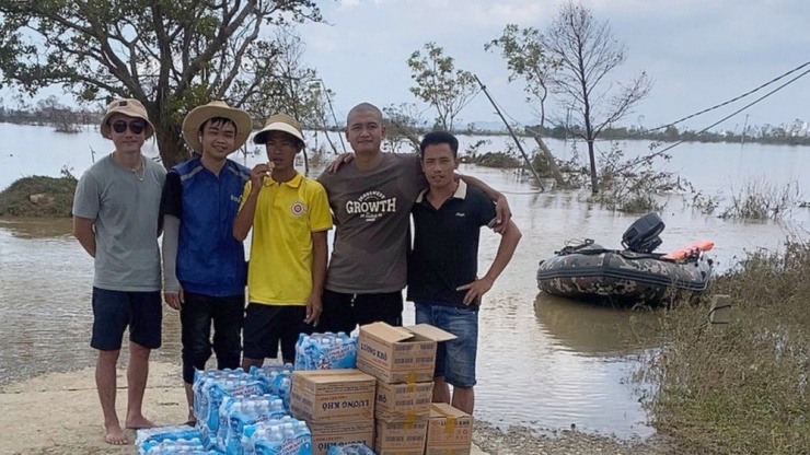 Anh Tùng cùng nhóm chuẩn bị nước uống, lương khô đưa lên cano đi cứu hộ người dân bị ngập lụt.