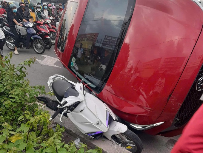 Một xe máy bị ôtô lật đè lên. Ảnh: Thái Hà