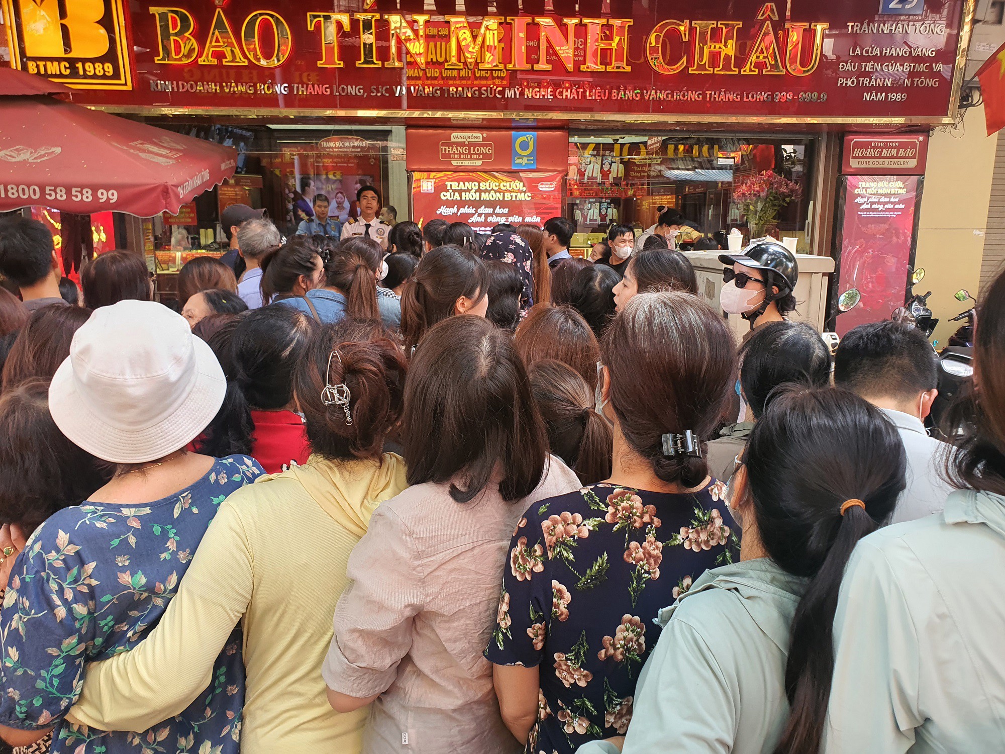 Trước một cửa hàng khác trên phố Trần Nhân Tông cũng gặp cảnh tương tự hàng trăm người xếp hàng quây kín cửa hàng vàng, tràn cả ra vỉa hè và xuống dưới lòng đường.