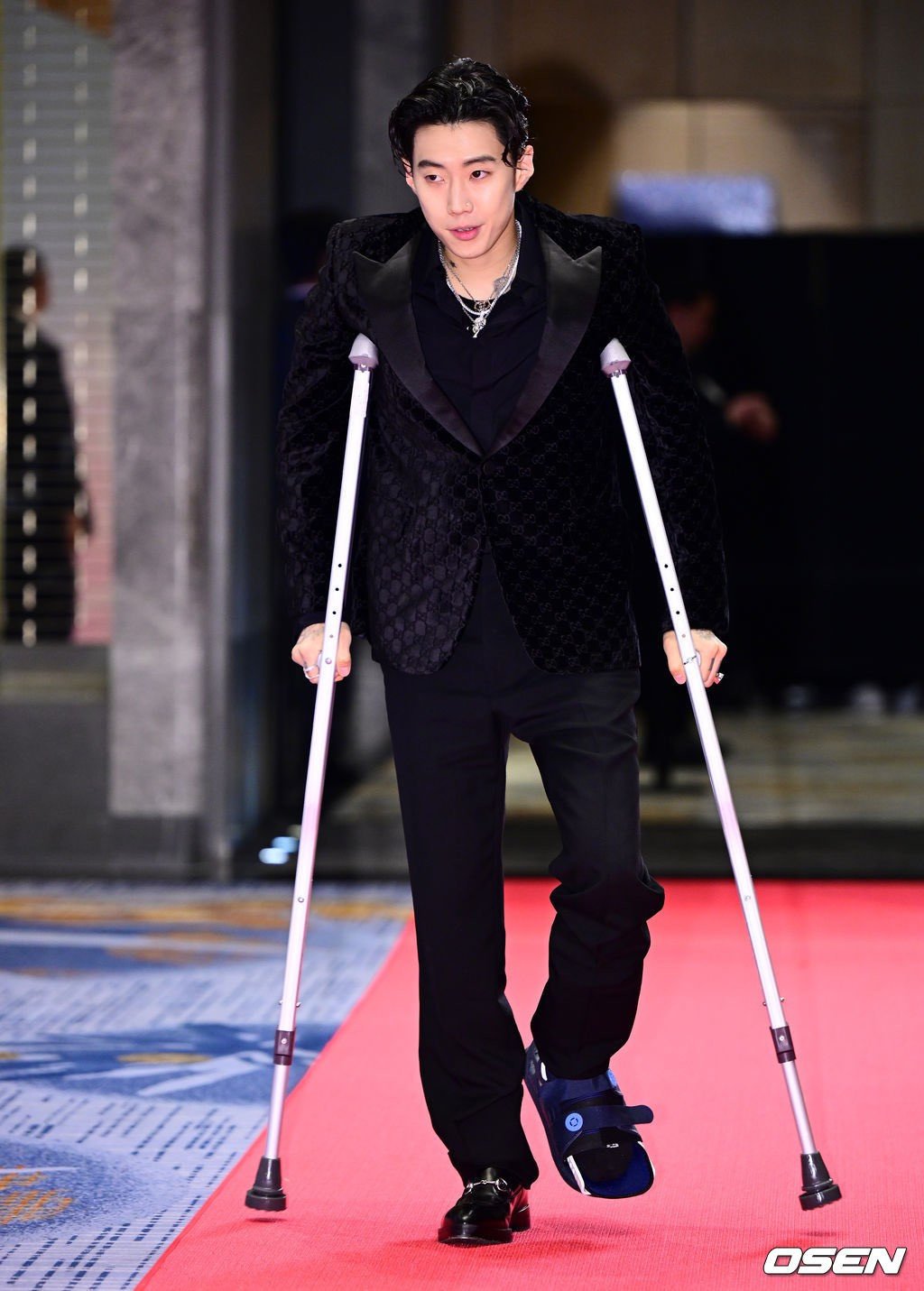 Jay Park chống nạng đi thảm đỏ.