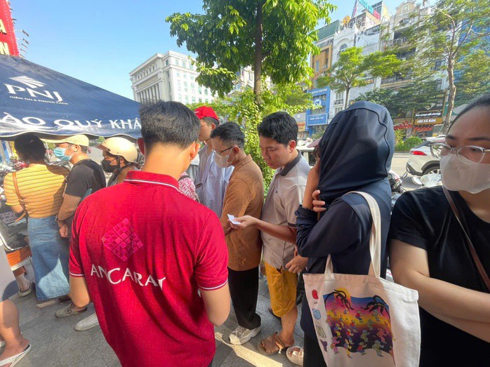 Nhân viên cửa hàng Ancarat phát số xếp hàng cho khách