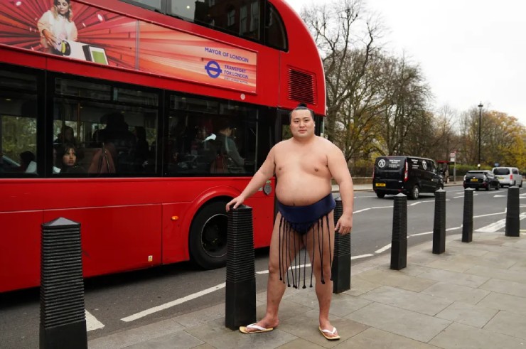 Võ sĩ Sumo tạo dáng bên chiếc xe buýt trên đường phố Anh