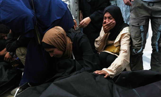 Người dân Palestine than khóc bên thi thể người thiệt mạng do hỏa lực của Israel tại Deir al-Balah, miền trung Dải Gaza hôm 19/10. Ảnh: AP