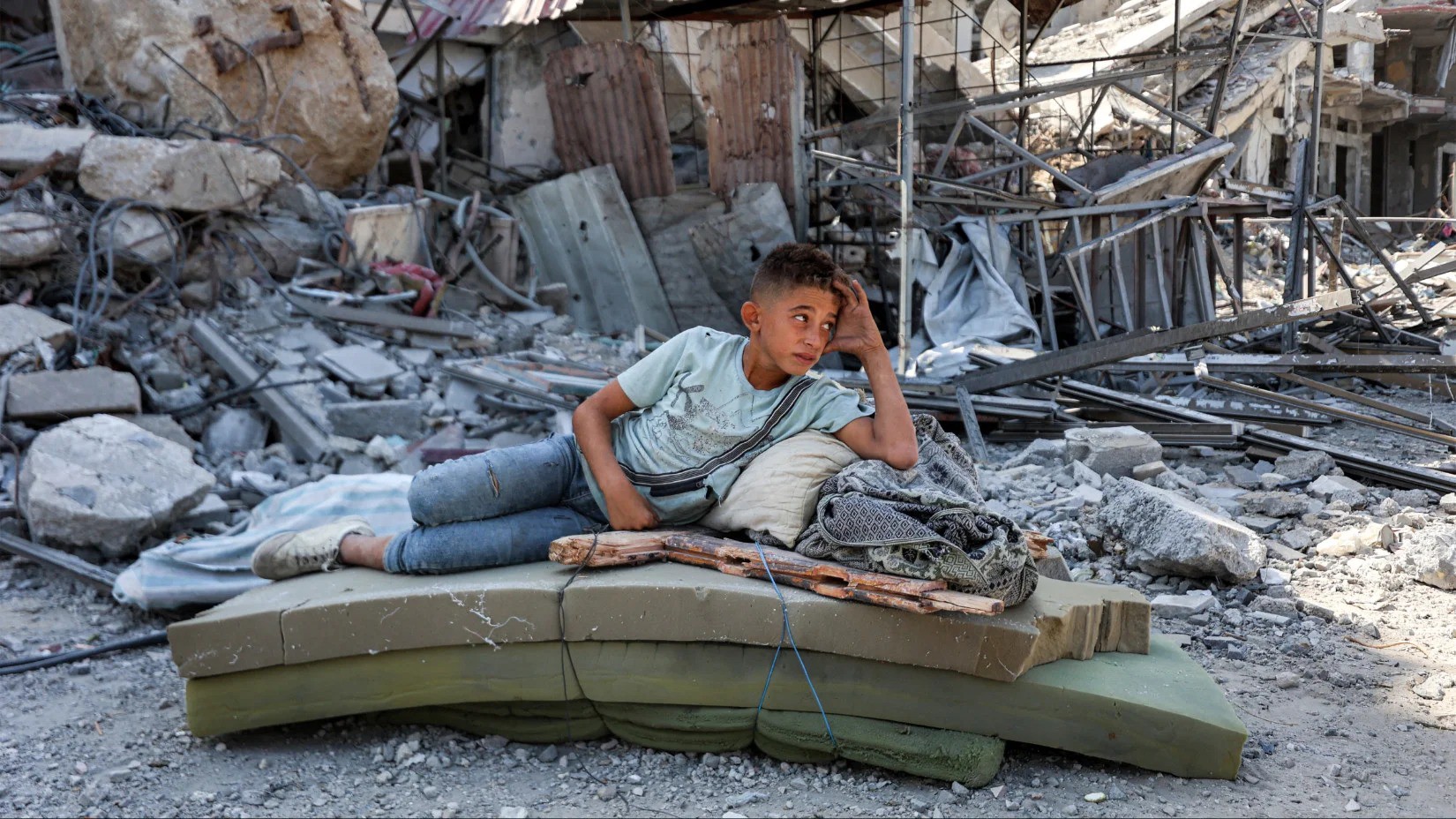 Một cậu bé Palestine ngồi nghỉ gần đống gạch vụn sau khi binh sĩ Israel rút khỏi Khan Younis, miền nam Dải Gaza, ngày 10/10/2025. Ảnh: AFP