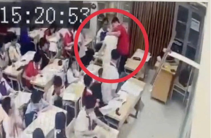 Hình ảnh học sinh túm tóc, ghì đầu giáo viên ngay trong lớp học (Ảnh chụp từ clip).