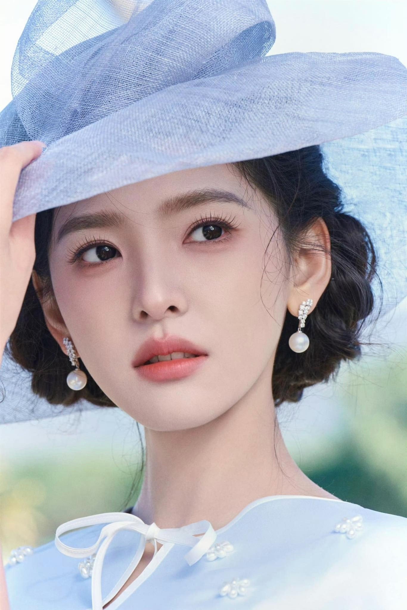 Chương Nhược Nam mặc bộ váy màu xanh nhạt có điểm nhấn ở phần eo rất độc đáo, kết hợp với áo choàng lửng đậm chất quý tộc. Tóc tết búi cao đi kèm mũ rộng vành là đủ để nữ diễn viên chính phim Khó Dỗ Dành biến hình thành tiểu thư những năm 1900 trong các cuốn truyện ngôn tình.