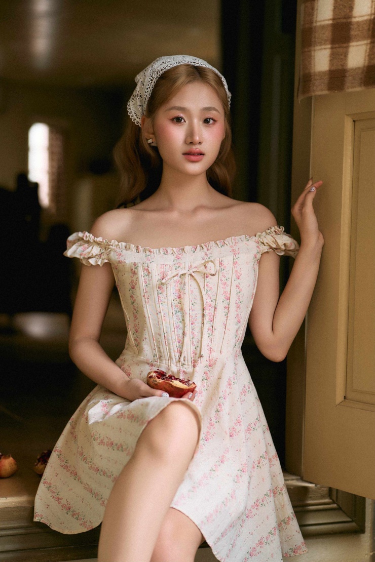 Ở một layout khác, XIRI xuất hiện với chiếc đầm xanh 2 dây pastel dịu mắt, tay cầm bó hoa cúc dại giản dị, thể hiện sự dịu dàng.