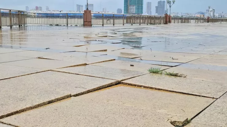 Gạch lát vỉa hè bong tróc dưới tác động của sóng vỗ. Ảnh: TẤN VIỆT