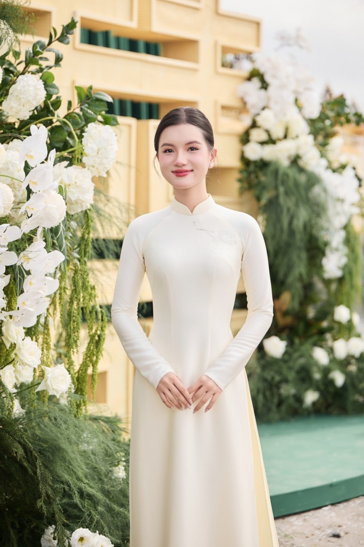 Người đẹp khoe nhan sắc mong manh với bộ áo dài kem vàng nhạt, được Đỗ Thị Hà đặt may riêng cho các phù dâu.