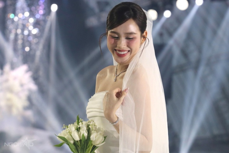 Đỗ Thị Hà e ấp trong bộ váy hở vai. Cô chọn hoa tulip trắng để cầm tay.