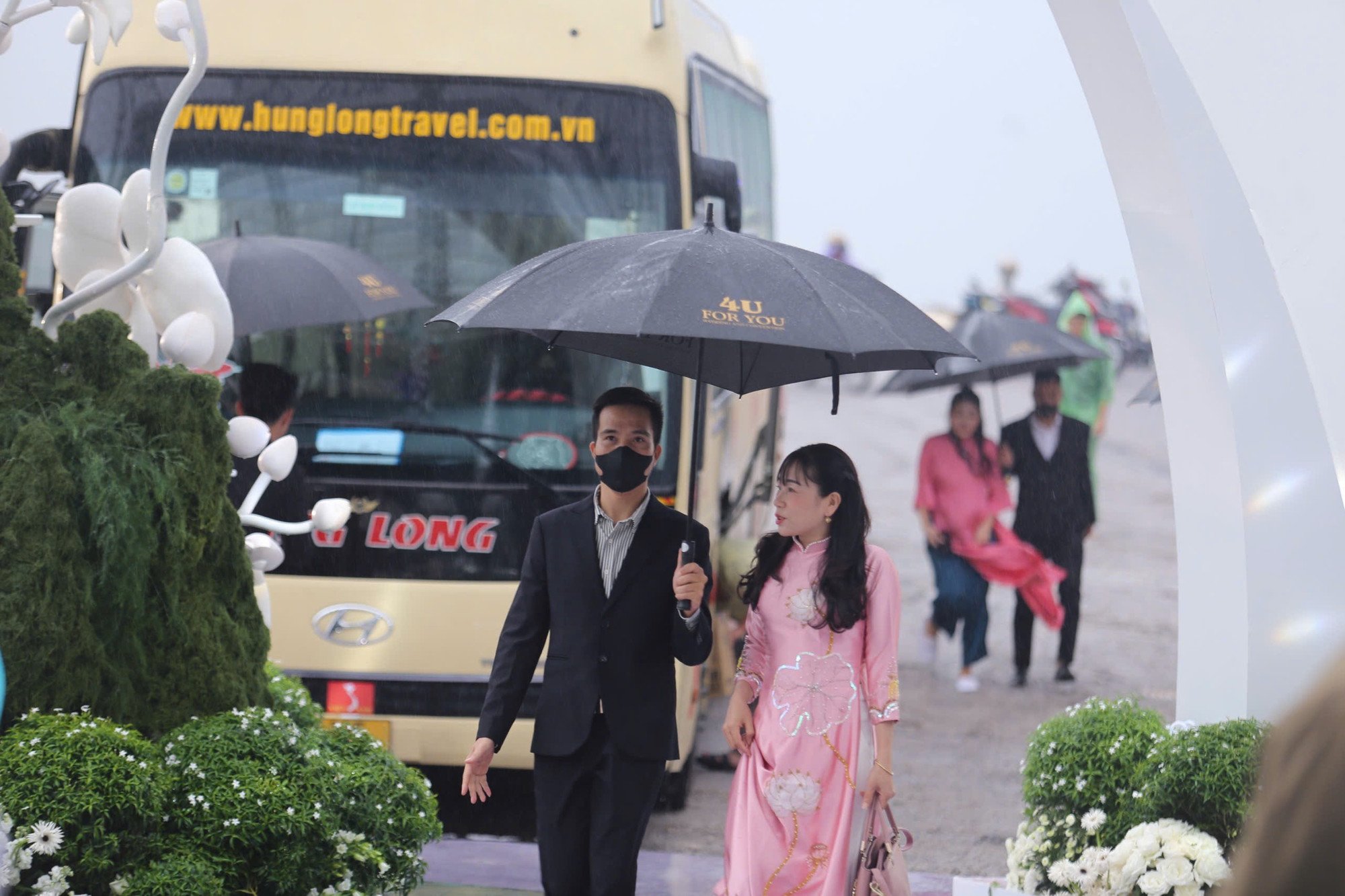 Do trời mưa nặng hạt, khách mời được dàn vệ sĩ che ô vào khu vực hôn trường Hoa hậu Đỗ Hà và doanh nhân Viết Vương.