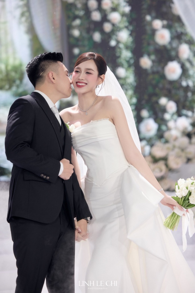 Chú rể Nguyễn Viết Vương diện suit bảnh bao được may đo riêng. Anh nắm chặt tay vợ không rời, cùng cô đón chào quan khách. Ảnh: Linh Lê Chí